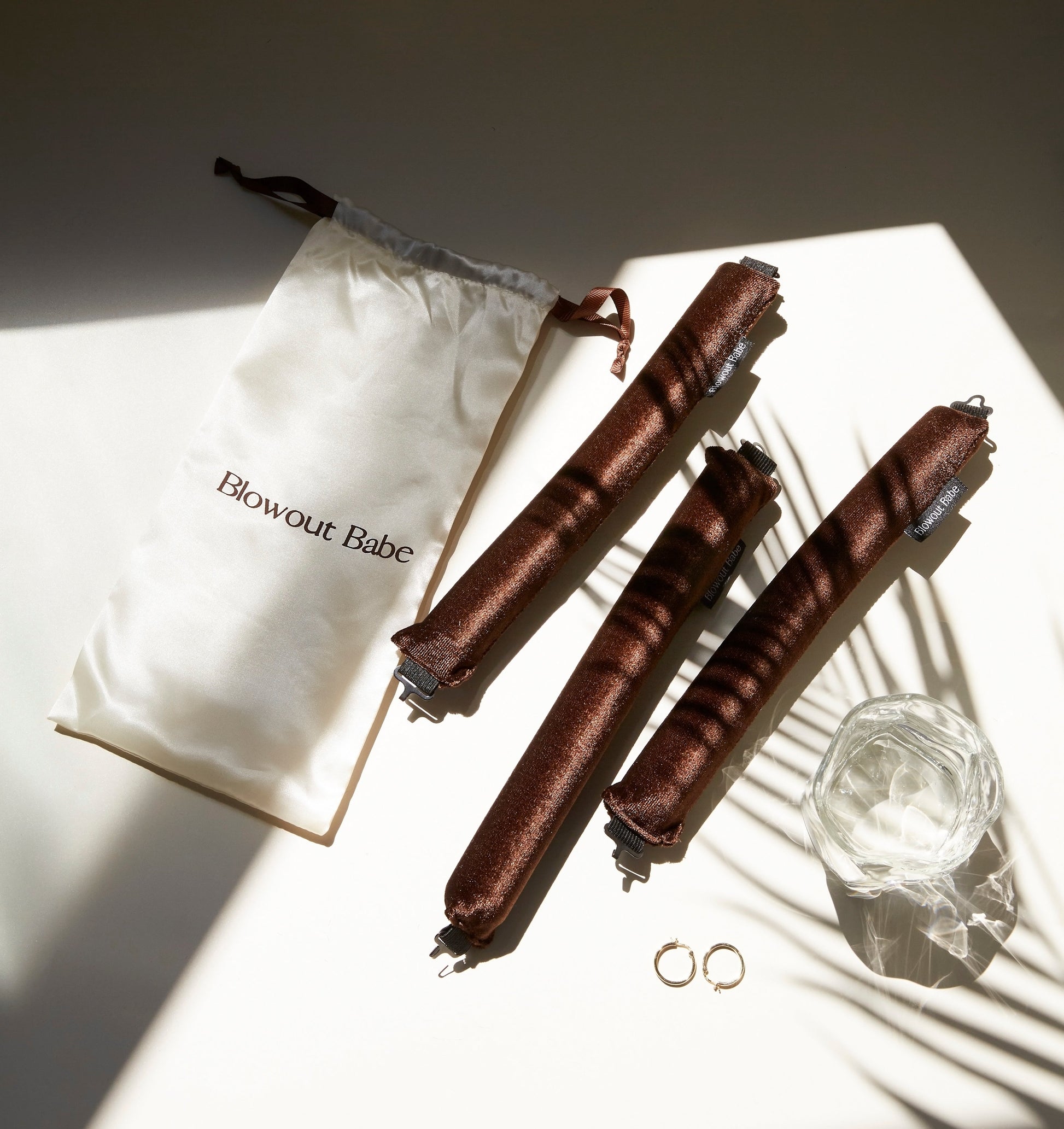 Brown Velvet Set flatlay with heatless rods, satin pouch and gold hoop earrings